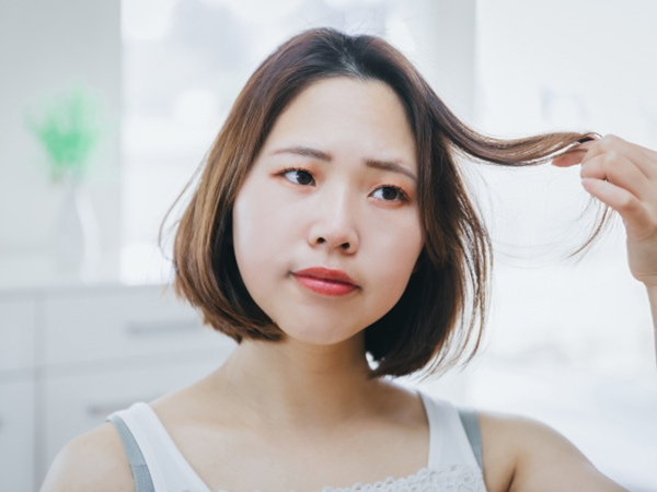 髪の毛のダメージに悩む女性